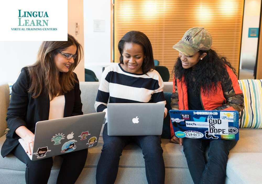 three students discussing while looking at laptop