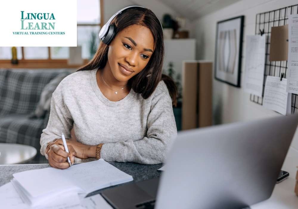Student wearing headphones, smiling while taking notes during an online class