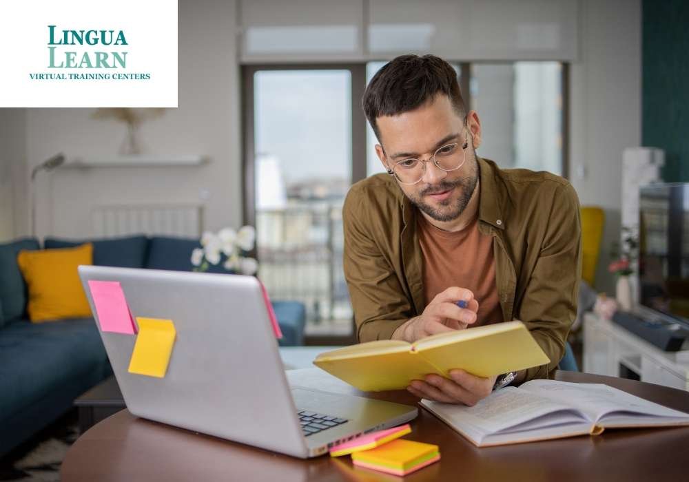 Man studying at a desk with a laptop and notebooks, taking notes