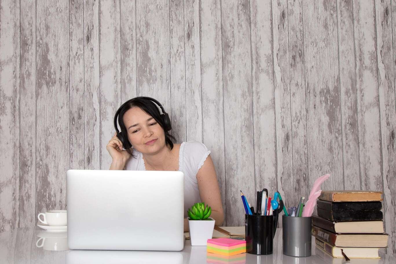 young lady with earphones using laptop